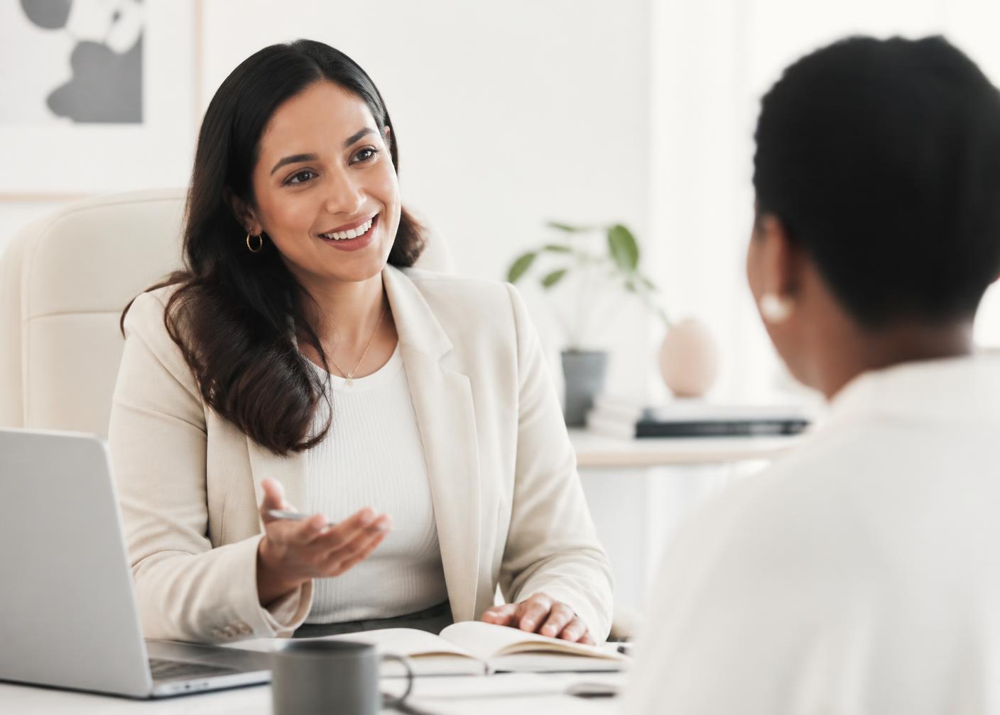 A career advisor in conversation with a professional in a bright modern office